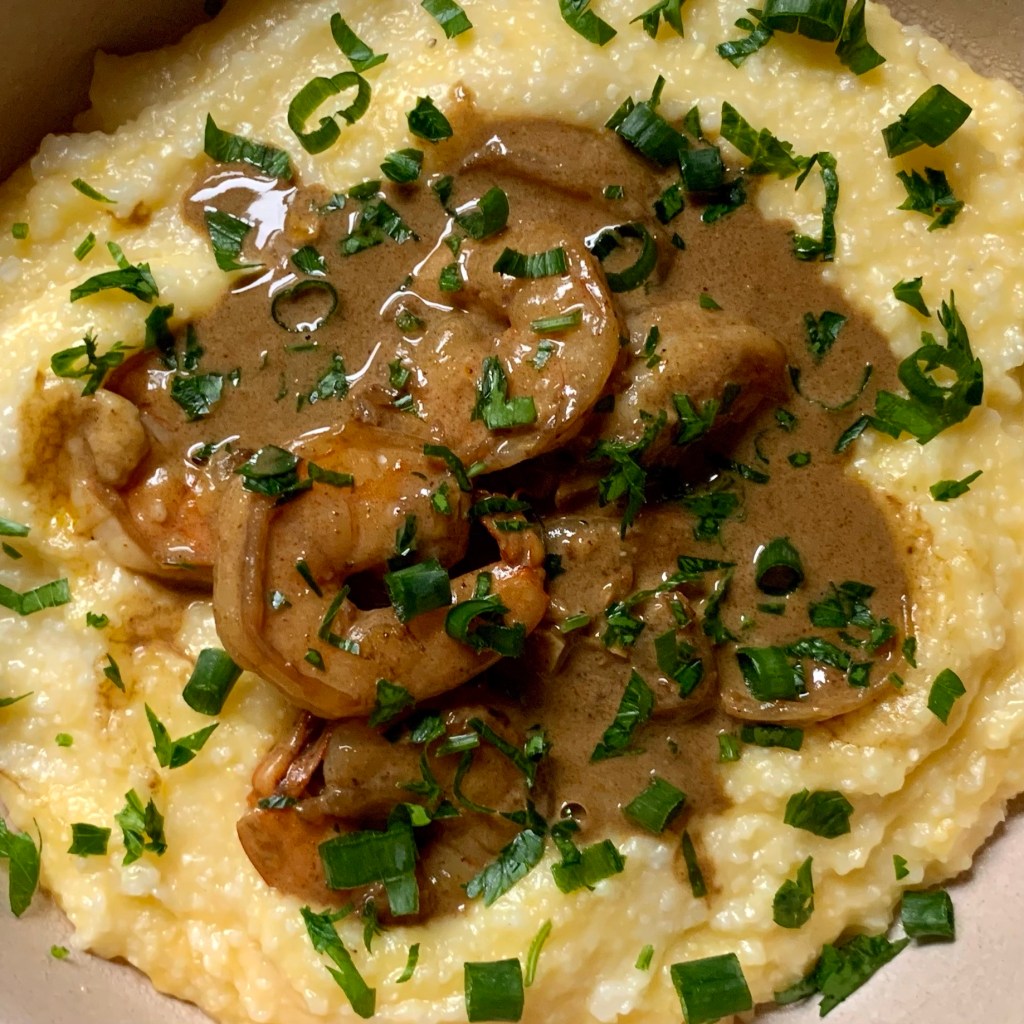 bowl of creamy shrimp and grits in a coconut truffle sauce