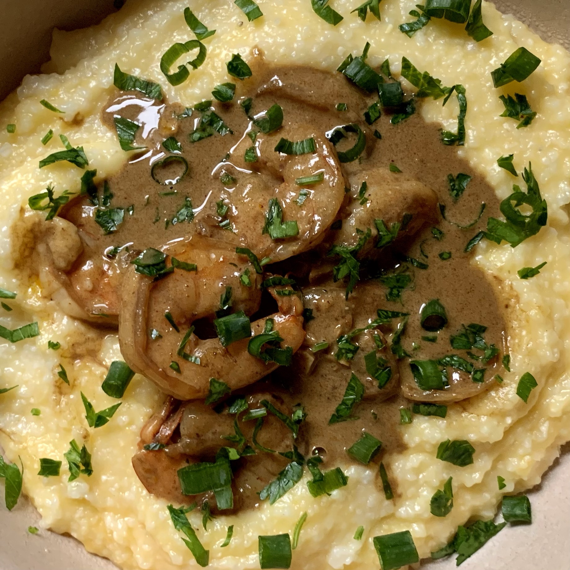 bowl of creamy shrimp and grits in a coconut truffle sauce