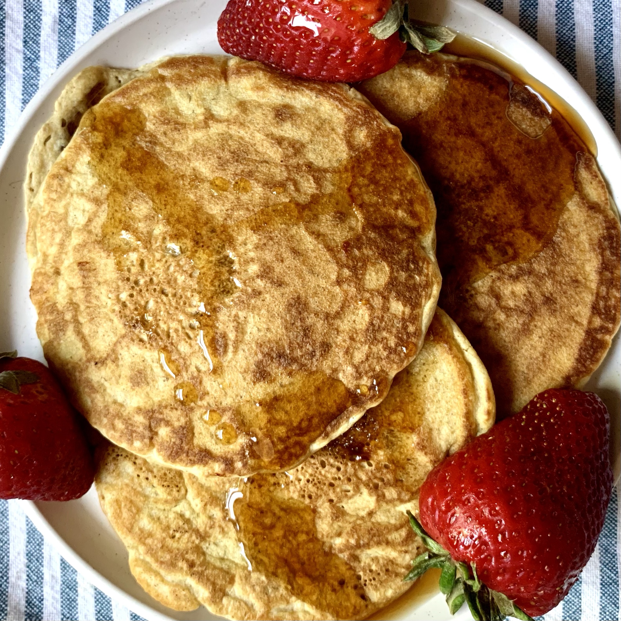 oat flour pancakes with maple syrup and strawberries